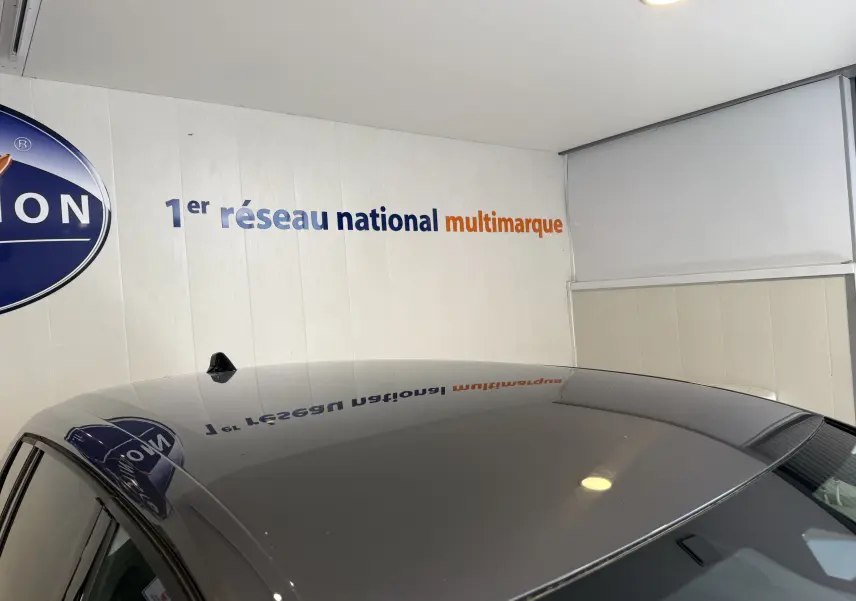 Toit gris métallisé d'une Opel Astra Sports Tourer 2024, vue en léger contre-plongée intérieure avec reflet mural.