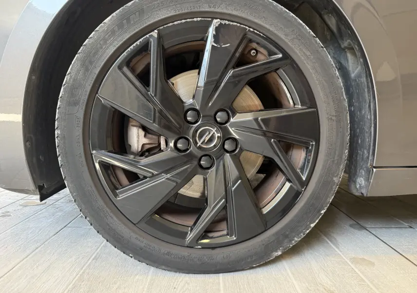 Gros plan sur la jante noire brillante de l’Opel Astra Sports Tourer gris 2024, mettant en valeur le logo central Opel.