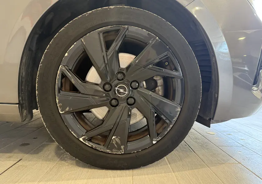 Gros plan sur la roue avant droite grise d’une Opel Astra Sports Tourer 2024 avec jante noire à éclats visibles.