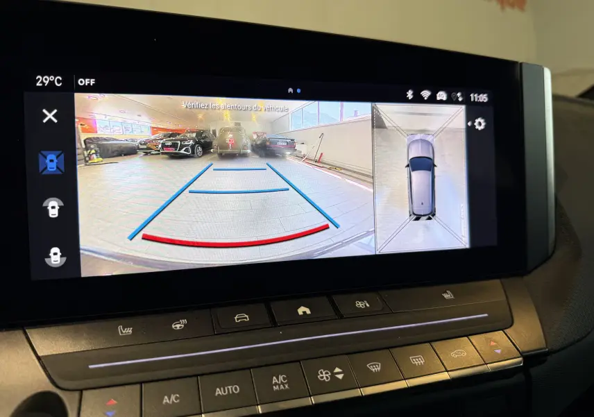 Écran intérieur de l’Opel Astra Sports Tourer 2024 montrant la caméra 360° avec vue arrière et vue aérienne du véhicule gris.