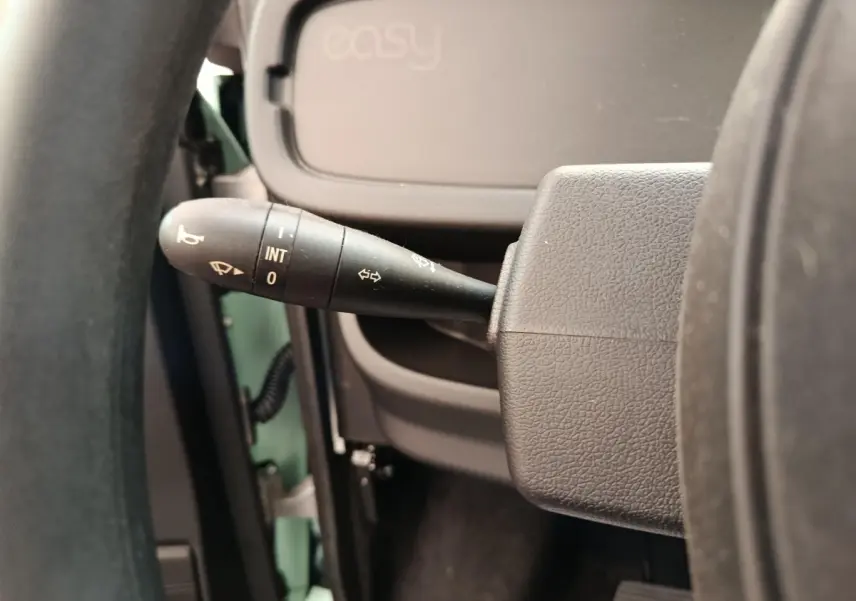 Gros plan sur la manette d’essuie-glace à gauche du volant d’une Aixam Ambition Easy Chic thermique verte.