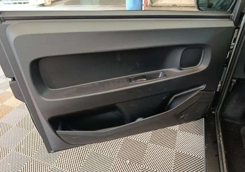 Détail de la porte intérieure côté gauche noire de l'AIXAM AMBITION Easy Chic thermique 2026, avec poignée intégrée.