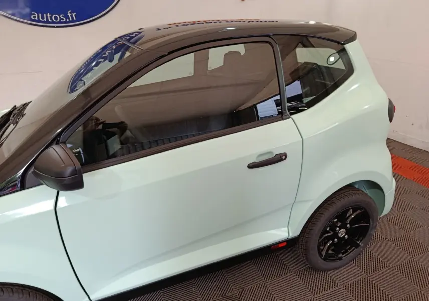 Vue latérale droite d'une Aixam Ambition Easy Chic thermique 2026 vert clair avec toit noir et jantes noires.