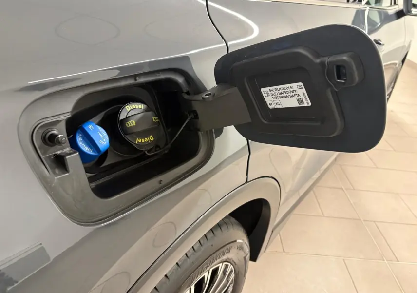 Gros plan sur la trappe à carburant côté gauche d'un Volkswagen Tiguan gris Dauphin, avec bouchons diesel et AdBlue visibles.