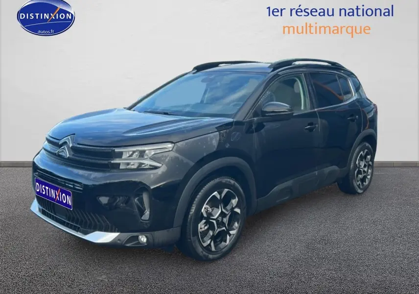 Citroën C5 Aircross noir vue 3/4 avant droit, avec jantes alu et barres de toit visibles.