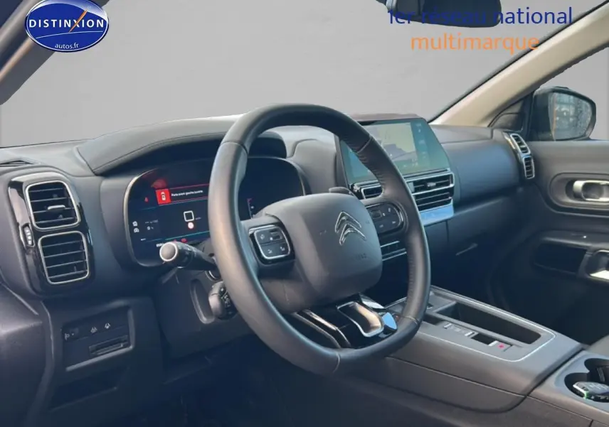 Vue intérieure côté conducteur du Citroën C5 Aircross noir 2025, volant cuir multifonction et écran tactile central.