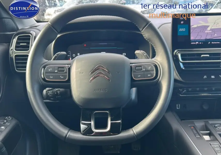 Vue centrée sur le volant cuir noir du Citroën C5 Aircross 2025 avec tableau de bord numérique et écran tactile.