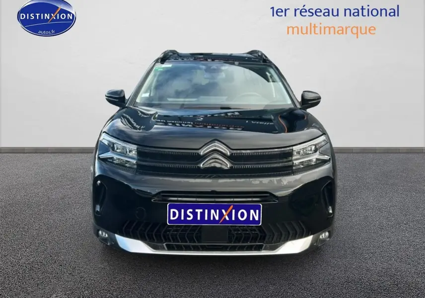 Vue avant d'un Citroën C5 Aircross noir 2025 avec calandre distinctive et phares LED allumés.