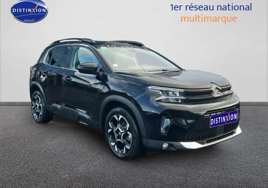 Citroën C5 Aircross noir en 3/4 avant droit, avec jantes alu et barres de toit visibles.