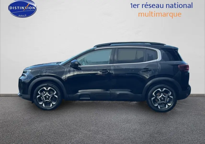 Profil côté gauche du Citroën C5 Aircross noir 2025 avec jantes alu et barres de toit visibles.