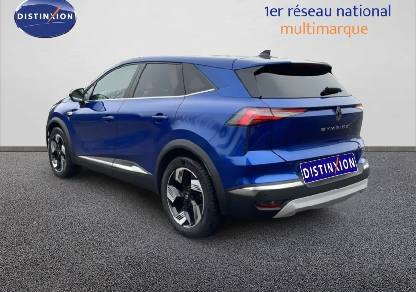 Vue 3/4 arrière droite d’un Renault Symbioz bleu Iron Metal avec jantes noires et détails chromés.