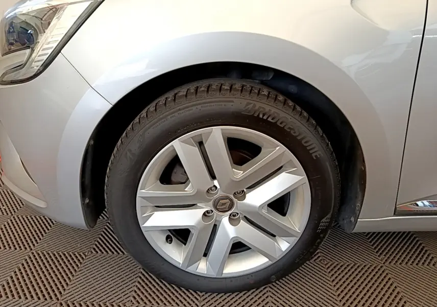 Gros plan sur la roue avant gauche gris clair d'une Renault Clio Business TCe 100 avec jante alliage cinq branches.