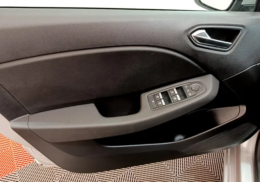 Vue rapprochée de la porte avant gauche gris clair de la Renault Clio Business TCe 100 avec commandes des vitres et rétroviseurs.
