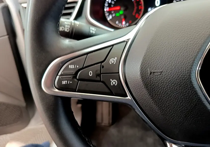 Gros plan sur les commandes du régulateur de vitesse au volant cuir noir de la Renault Clio Business TCe 100 2020.