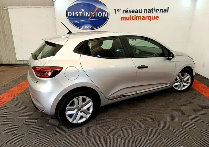 Renault Clio Business TCe 100 2020 gris clair vue 3/4 arrière droit dans un showroom avec logo Distinxion.