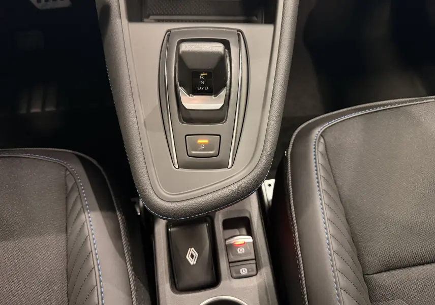 Vue rapprochée de la console centrale du Renault Captur E-Tech 2026, avec levier de vitesse électronique et surpiqûres bleues.