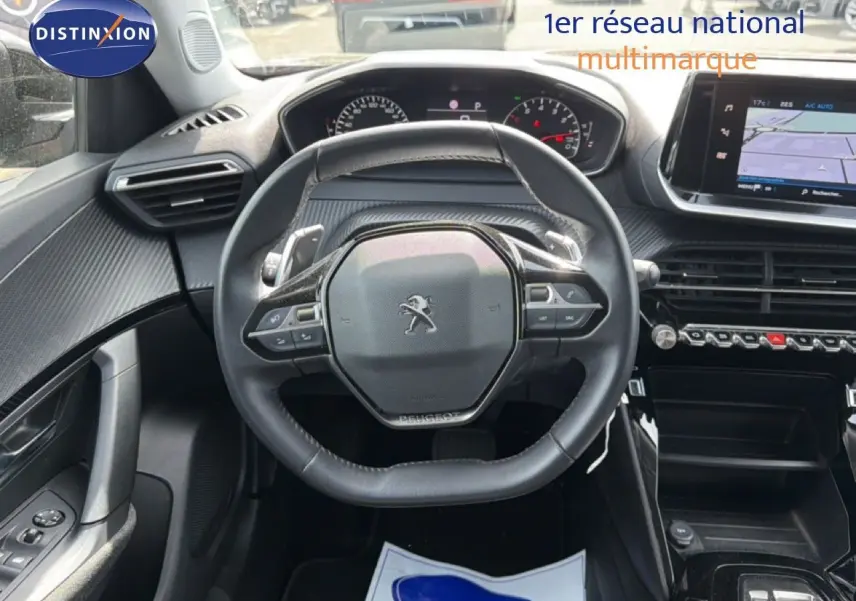 Vue intérieure centrée sur le volant compact de la Peugeot 2008 2022 avec tableau de bord et écran tactile visibles.