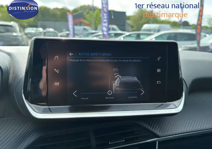 Écran tactile central du Peugeot 2008 noir perle métal de 2022 affichant le réglage de l'Active Safety Brake en extérieur.