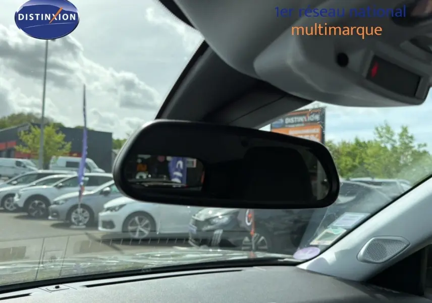 Vue intérieure centrée sur le rétroviseur intérieur d'une Peugeot 2008 noir perle métal, avec tableau de bord partiellement visible.