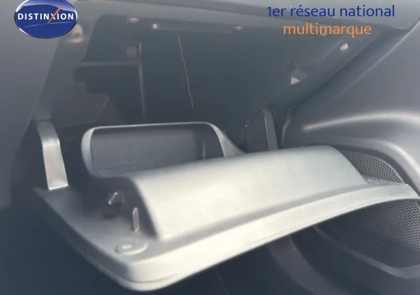 Gros plan sur la boîte à gants ouverte de la Peugeot 2008 noire perle métal, intérieur sombre et moderne.