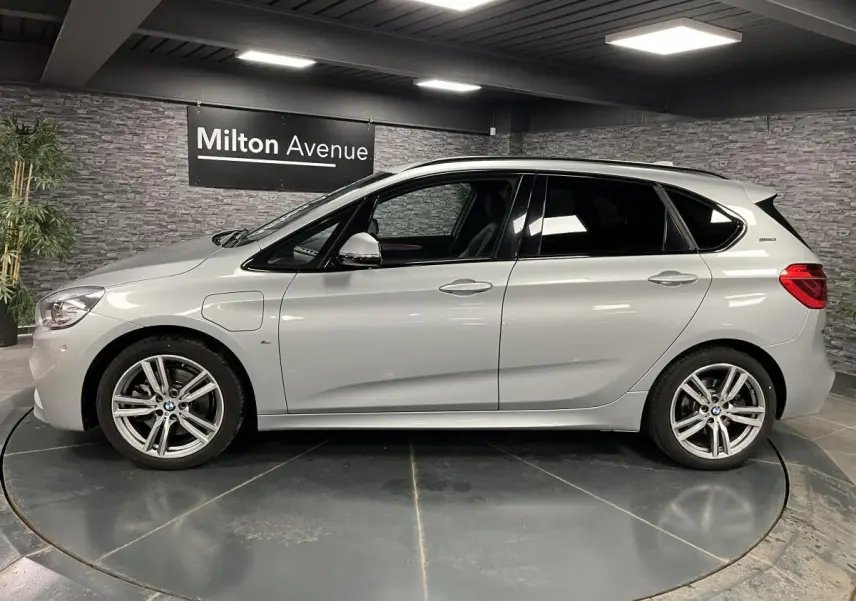 BMW Série 2 225xe Active Tourer gris vue de profil côté gauche, avec jantes alliage et badge eDrive visible.