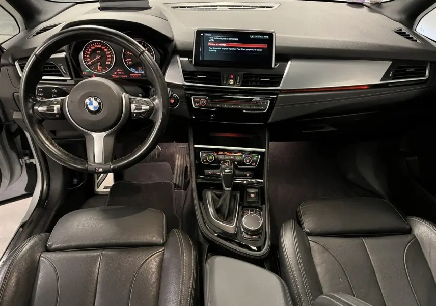 Vue intérieure avant de la BMW Série 2 225xe M Sport 2018, avec tableau de bord noir et volant cuir M.