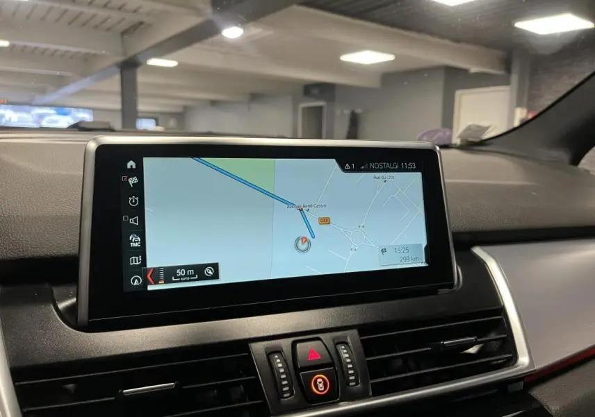 Écran de navigation central intérieur de BMW Série 2 gris, avec affichage carte et commandes autour.