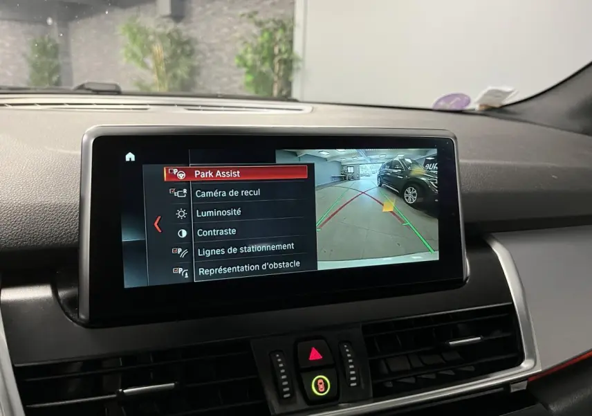 Écran intérieur de la BMW Série 2 225xe gris montrant la caméra de recul et l'assistance au stationnement.