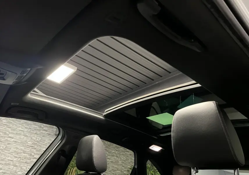 Vue intérieure du toit ouvrant panoramique en verre et des sièges avant en cuir noir de la BMW Série 2 225xe Active Tourer M Sport.