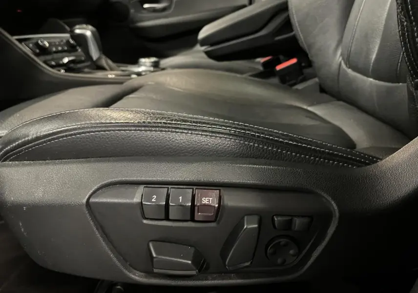 Détail des commandes électriques de réglage du siège conducteur en cuir noir dans une BMW Série 2 225xe Active Tourer.