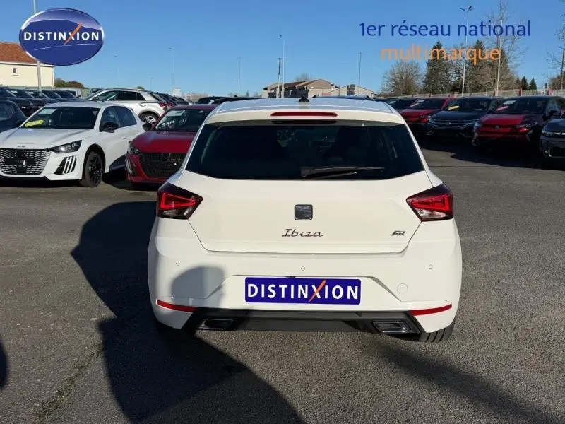 Vue arrière d'une SEAT Ibiza 1.0 TSI FR blanche Nevada métallisée, avec feux LED et double sortie d'échappement.