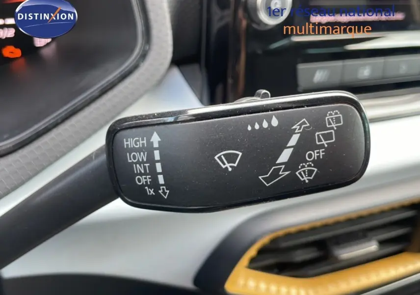 Gros plan sur la commande d’essuie-glace du SEAT Arona 2025 rouge désir métal avec toit noir, intérieur moderne visible.
