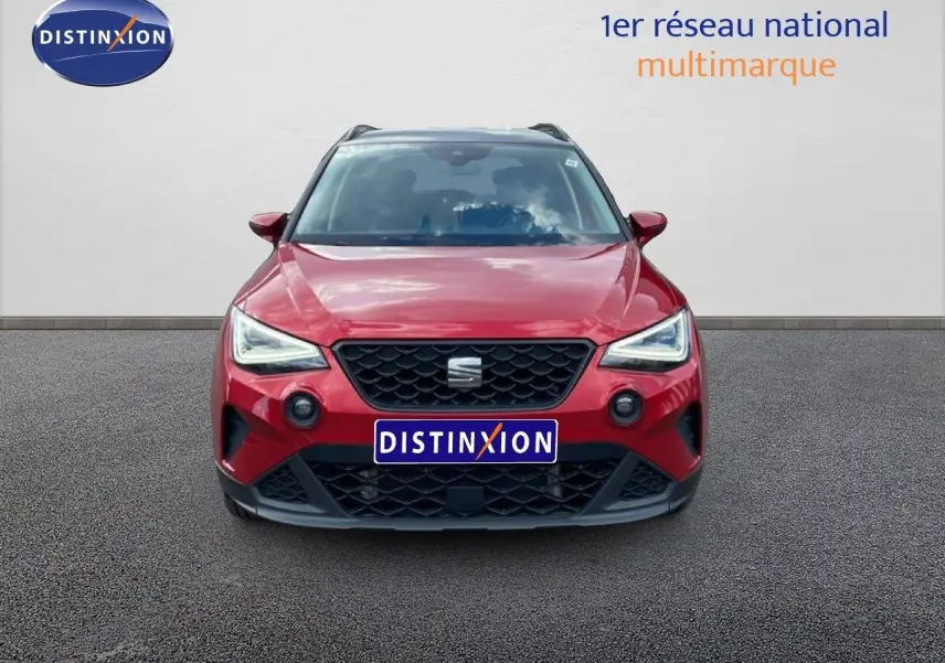 Vue avant d'un SEAT Arona rouge Désir Métal avec toit noir, calandre noire et feux LED allumés.