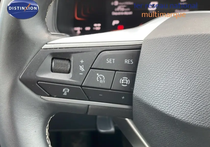 Gros plan sur les commandes au volant du SEAT Arona 2025, mettant en valeur les boutons de régulateur et d'assistance.