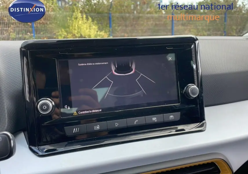 Écran tactile du système d'aide au stationnement dans l'habitacle d'une SEAT Arona rouge avec toit noir.