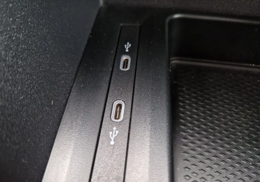 Gros plan sur deux ports USB-C noirs intégrés dans la console centrale du Volkswagen Caddy Cargo blanc 2023.