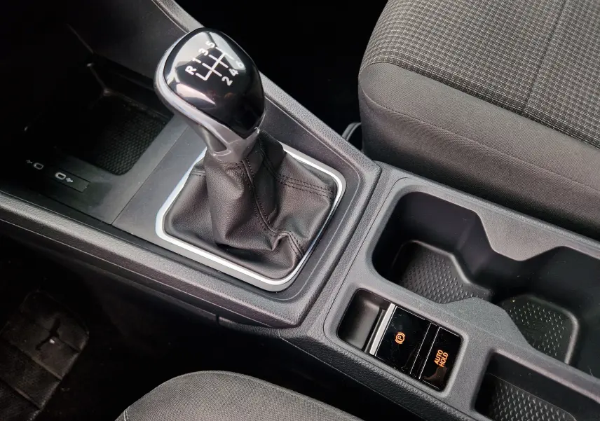 Gros plan sur le levier de vitesses manuel noir et la console centrale avec frein à main électronique du Volkswagen Caddy Cargo 2023.