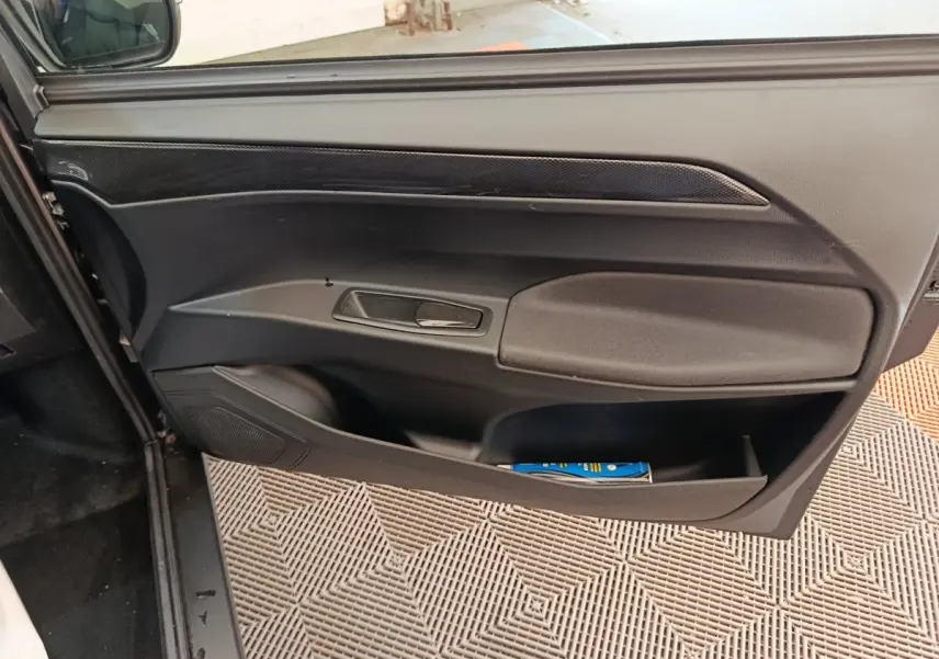 Vue rapprochée de la porte côté conducteur noire de l'AIXAM AMBITION 0.5 CITY COUPE GTI avec poignée intégrée.