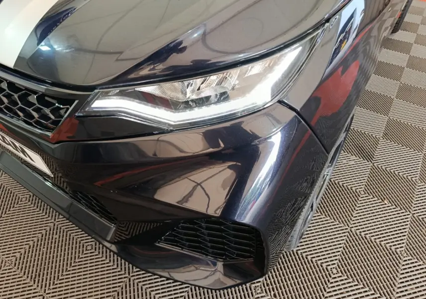 Gros plan sur l'avant droit noir de l'AIXAM AMBITION 0.5 CITY COUPE GTI 2026 avec phares LED et calandre ajourée.
