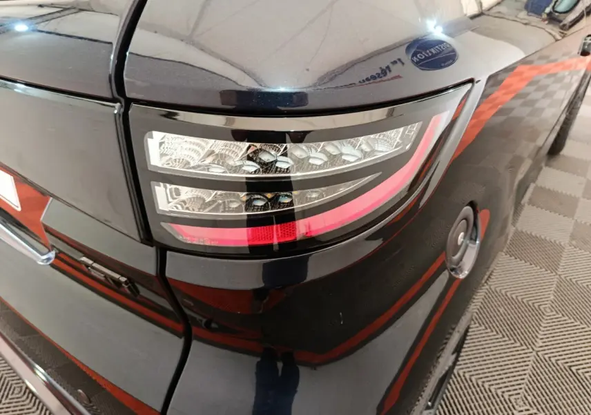 Gros plan sur le feu arrière droit noir brillant de l'AIXAM Ambition 0.5 City Coupe GTI 2026 avec réservoir visible.