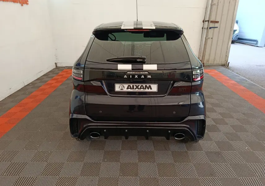 Vue arrière d'une Aixam Ambition 0.5 City Coupe GTI noire avec bandes blanches et double sortie d'échappement.