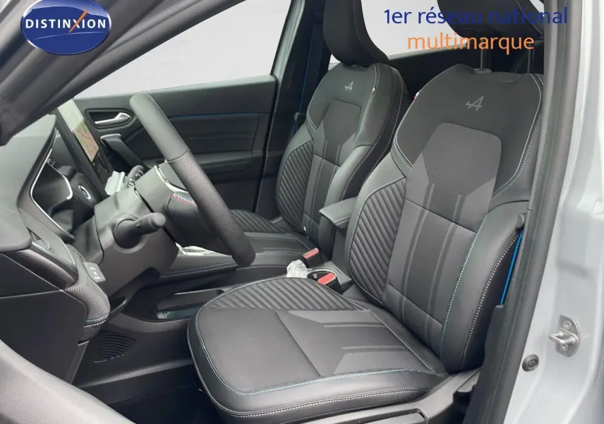 Vue intérieure côté conducteur de la Renault Symbioz 2025, sièges noirs avec surpiqûres bleues et logo Alpine brodé.