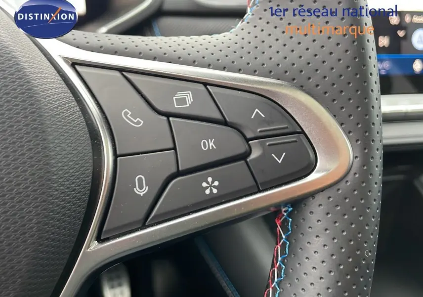 Gros plan sur les commandes multifonctions du volant en cuir perforé noir du Renault Symbioz gris Rafale Metal.