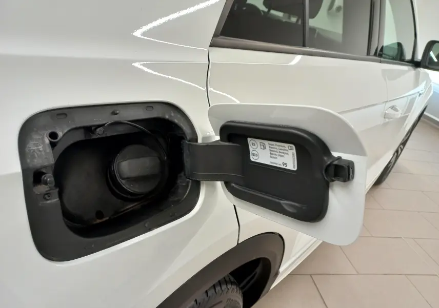 Vue rapprochée du coffre à carburant ouvert côté gauche d’un Volkswagen T-Roc blanc pur 2025.