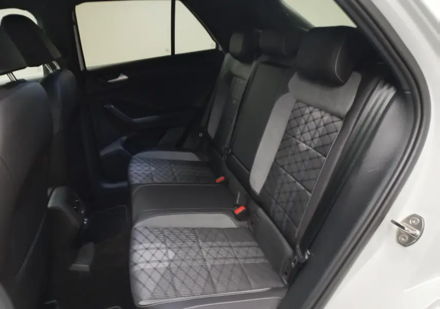 Vue intérieure côté droit des sièges arrière en cuir noir et tissu gris à motifs géométriques du Volkswagen T-Roc blanc pur 2025.