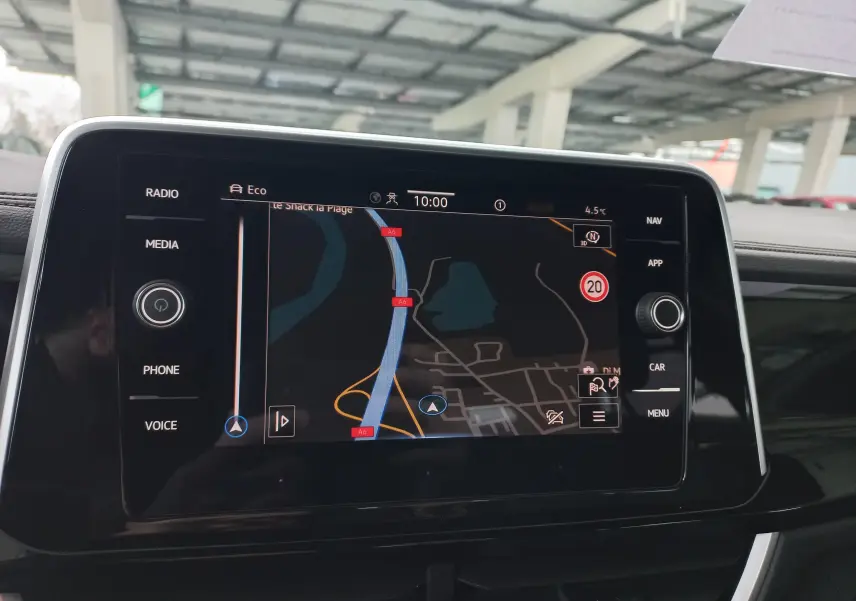 Écran tactile central du Volkswagen T-Roc 2025 affichant la navigation, avec commandes médias et téléphone visibles.