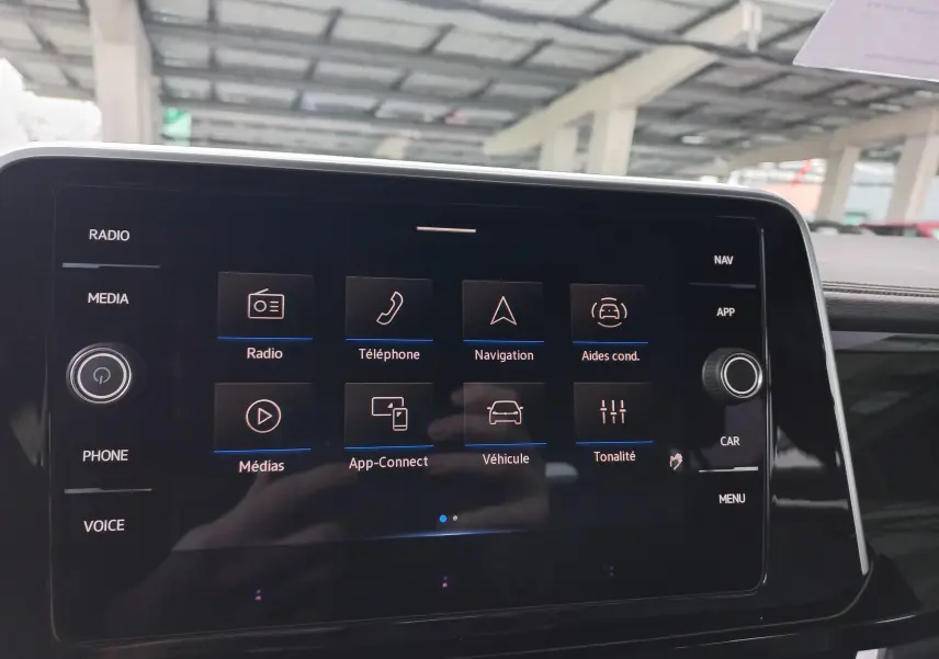 Vue rapprochée de l’écran tactile central du Volkswagen T-Roc 2025, affichant les options multimédias et de navigation.