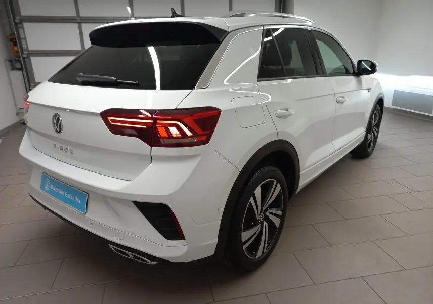 Volkswagen T-Roc blanc pur en 3/4 arrière droit, avec feux arrière LED et jantes alliage distinctives R-Line.