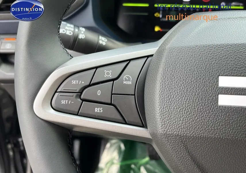Gros plan sur les commandes multifonctions à gauche du volant du Dacia Duster 2025, intérieur gris et noir.