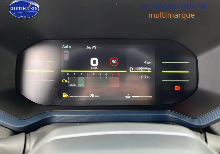 Tableau de bord numérique du Dacia Duster 2025 affichant la vitesse, compte-tours et alertes, vue frontale rapprochée.